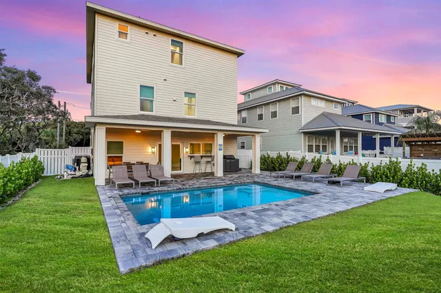 a view of a house with a yard patio and swimming pool