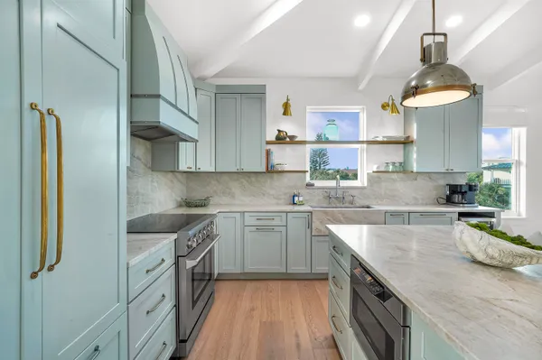 a living room with furniture kitchen view and a large window