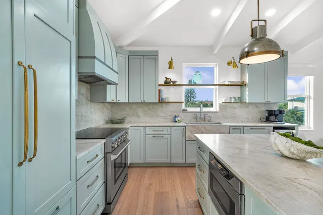 a living room with furniture kitchen view and a large window