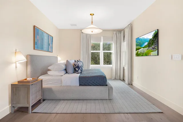 a spacious bedroom with a balcony a bed and a flat screen tv