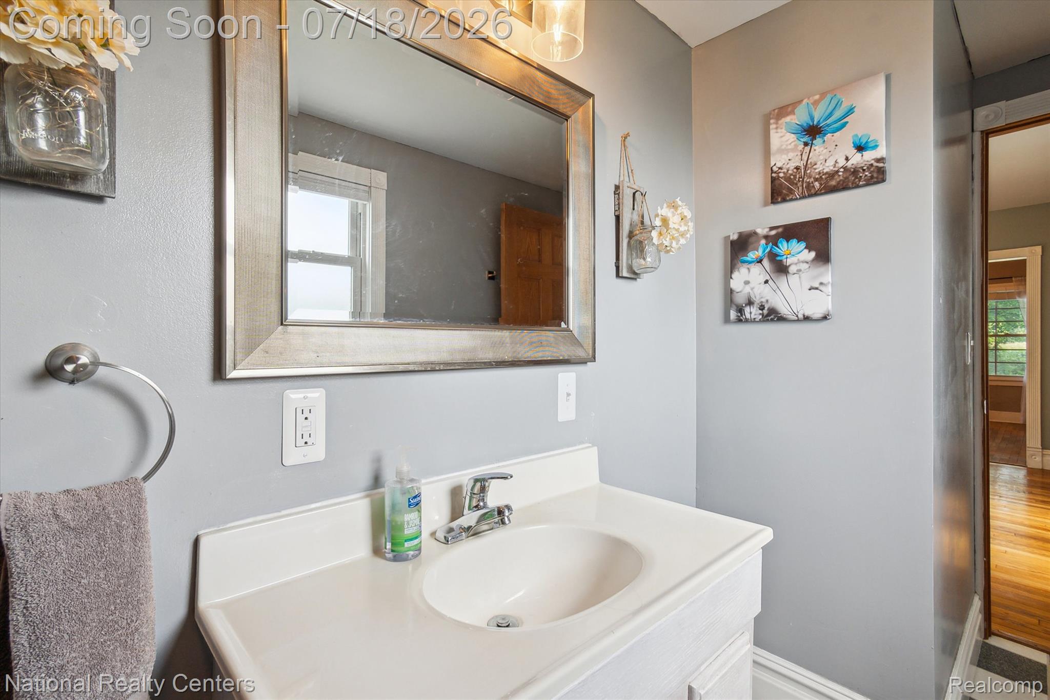 9589 Clinton Macon Road Tecumseh, MI 49286 - Photo 14 of 48 Vanity with integrated sink and countertop, framed mirror, wall-mounted light fixture, and brushed nickel faucet