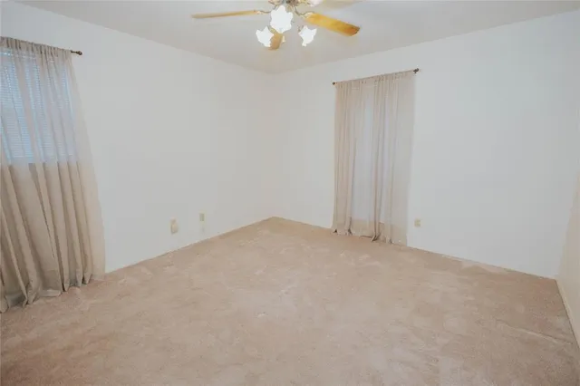 an empty room with a chandelier fan