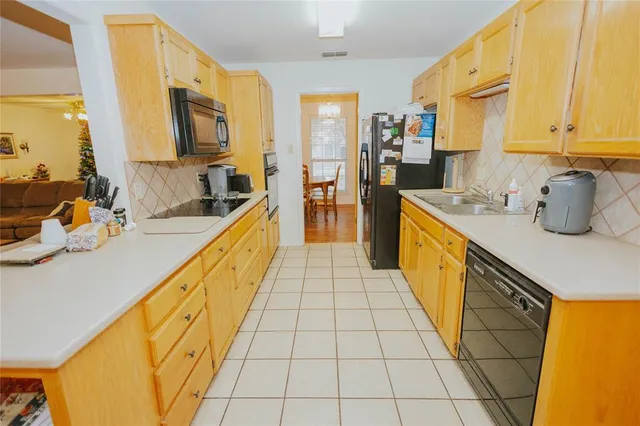 a large kitchen with stainless steel appliances a sink counter space and a window