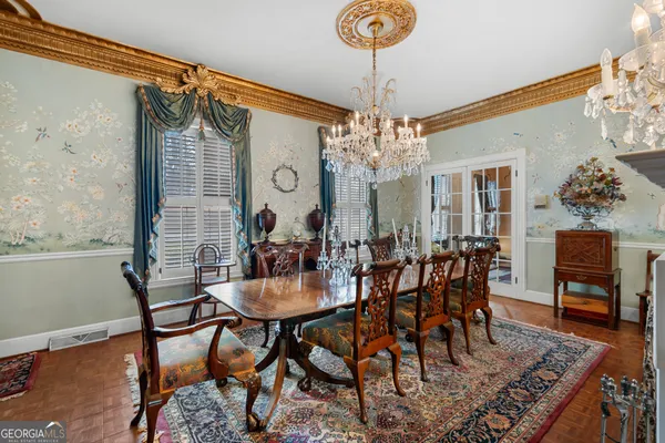 a view of a dining room with furniture and chandelier