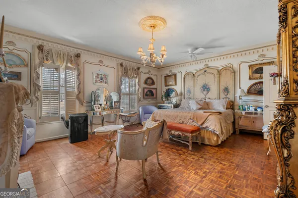 a spacious bedroom with a bed chandelier and a window