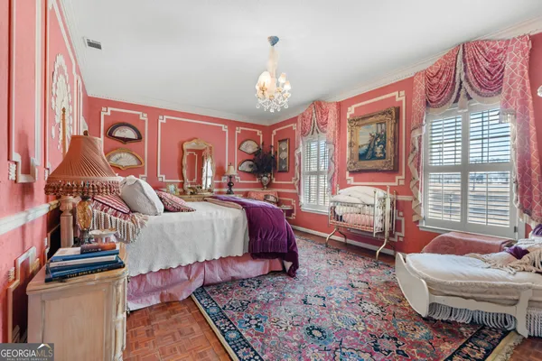 a spacious bedroom with a bed and a chandelier