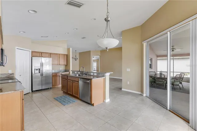a large kitchen with stainless steel appliances granite countertop a refrigerator and a sink