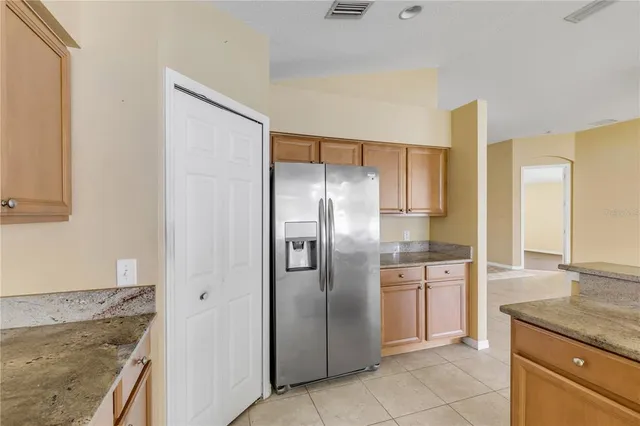 a kitchen with stainless steel appliances granite countertop a refrigerator and a sink