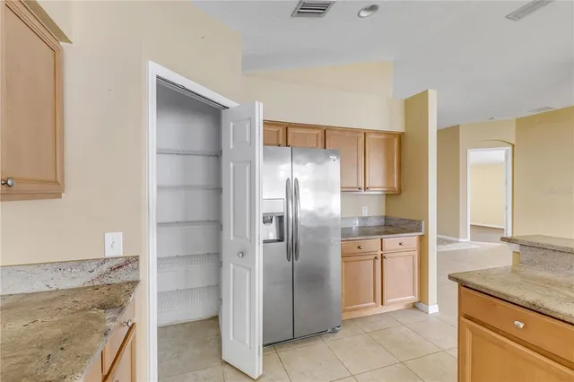 a kitchen with stainless steel appliances granite countertop a refrigerator and a sink