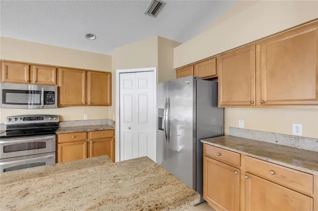 a kitchen with stainless steel appliances granite countertop a refrigerator sink and stove