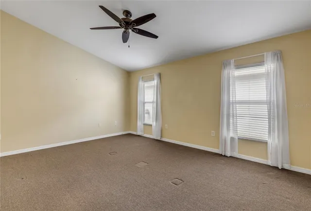 an empty room with a ceiling fan and a window