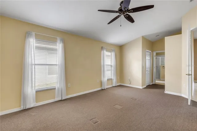 a view of a room with a ceiling fan and a window