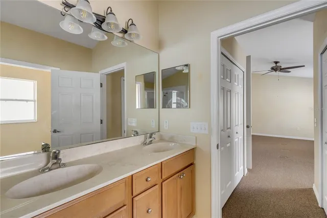 a bathroom with a granite countertop sink a large mirror and a shower