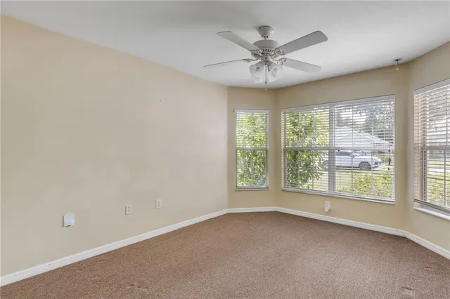 an empty room with a window and a fan