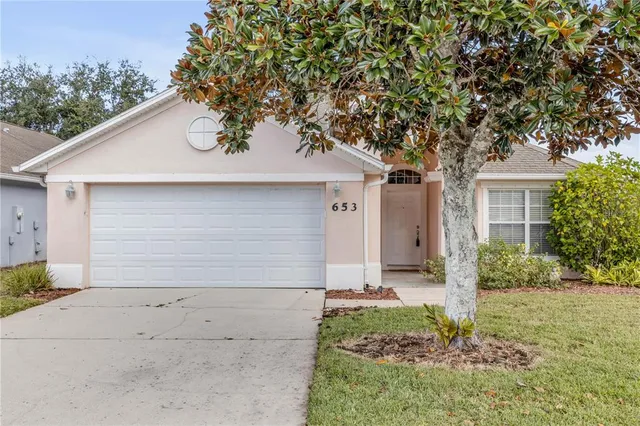 a small white house with a tree in front of it