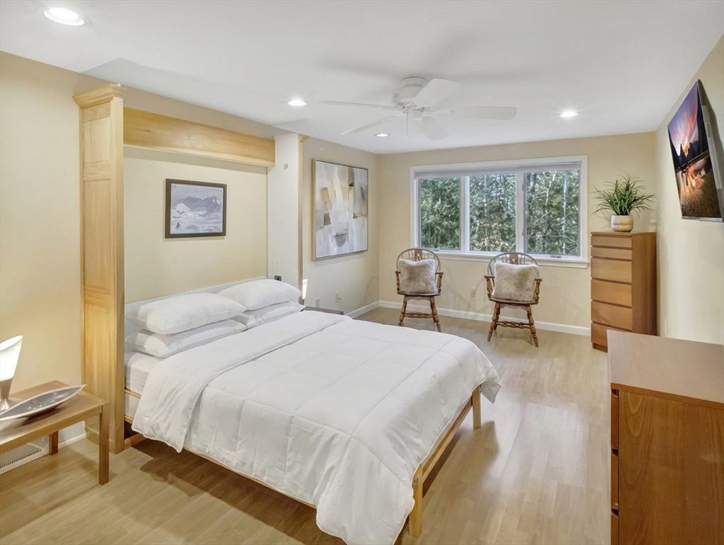 10 Kettle Lane, Unit 10 Mashpee, MA 02649 - Photo 21 of 25 a bedroom with a bed and wooden floor