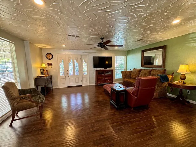 a living room with furniture wooden floor and a flat screen tv