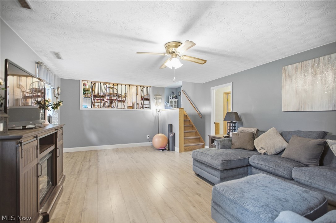 5972 Keller Road Akron, OH 44319 - Photo 6 of 29 Wood-finish flooring, recessed window, ceiling fan with integrated lighting, and a staircase with a wood handrail