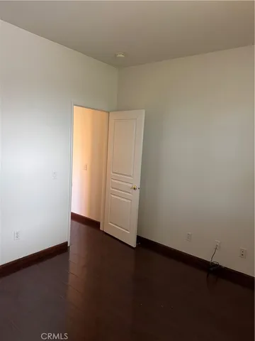 an empty room with a wooden floor and white walls