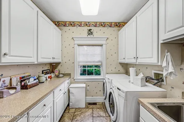 a kitchen with stainless steel appliances granite countertop a refrigerator a stove top oven a sink a dining table and chairs