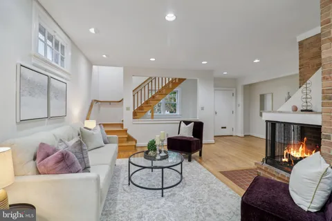 a living room with furniture a fireplace and a chandelier