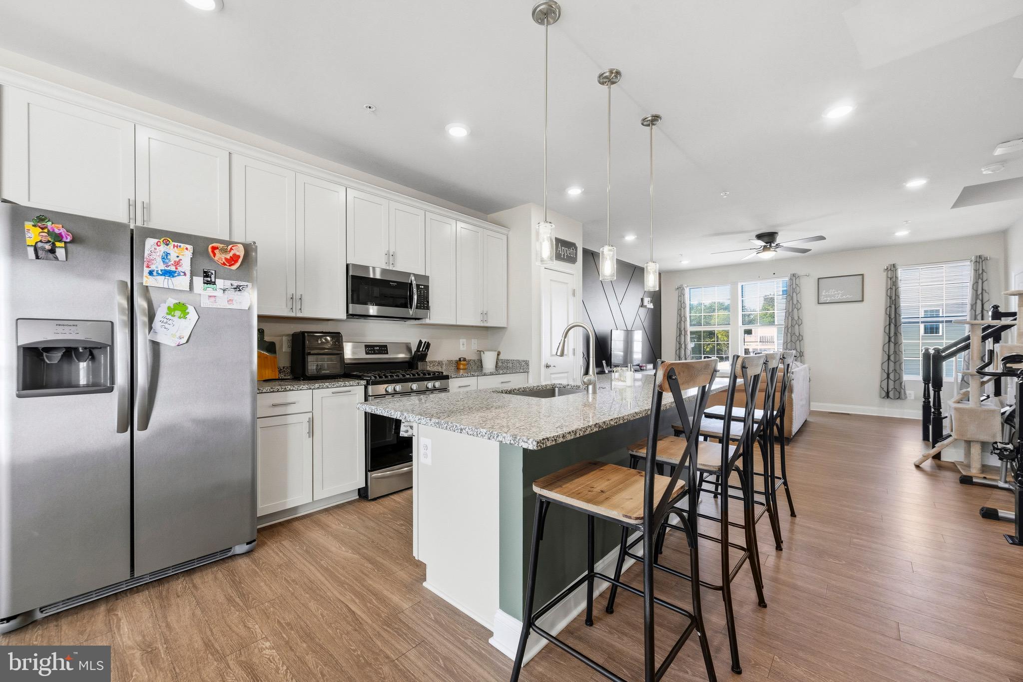 403 Dryden Road Aberdeen, MD 21001 - Photo 7 of 44 a kitchen with stainless steel appliances granite countertop a refrigerator a stove a sink a dining table and chairs with wooden floor