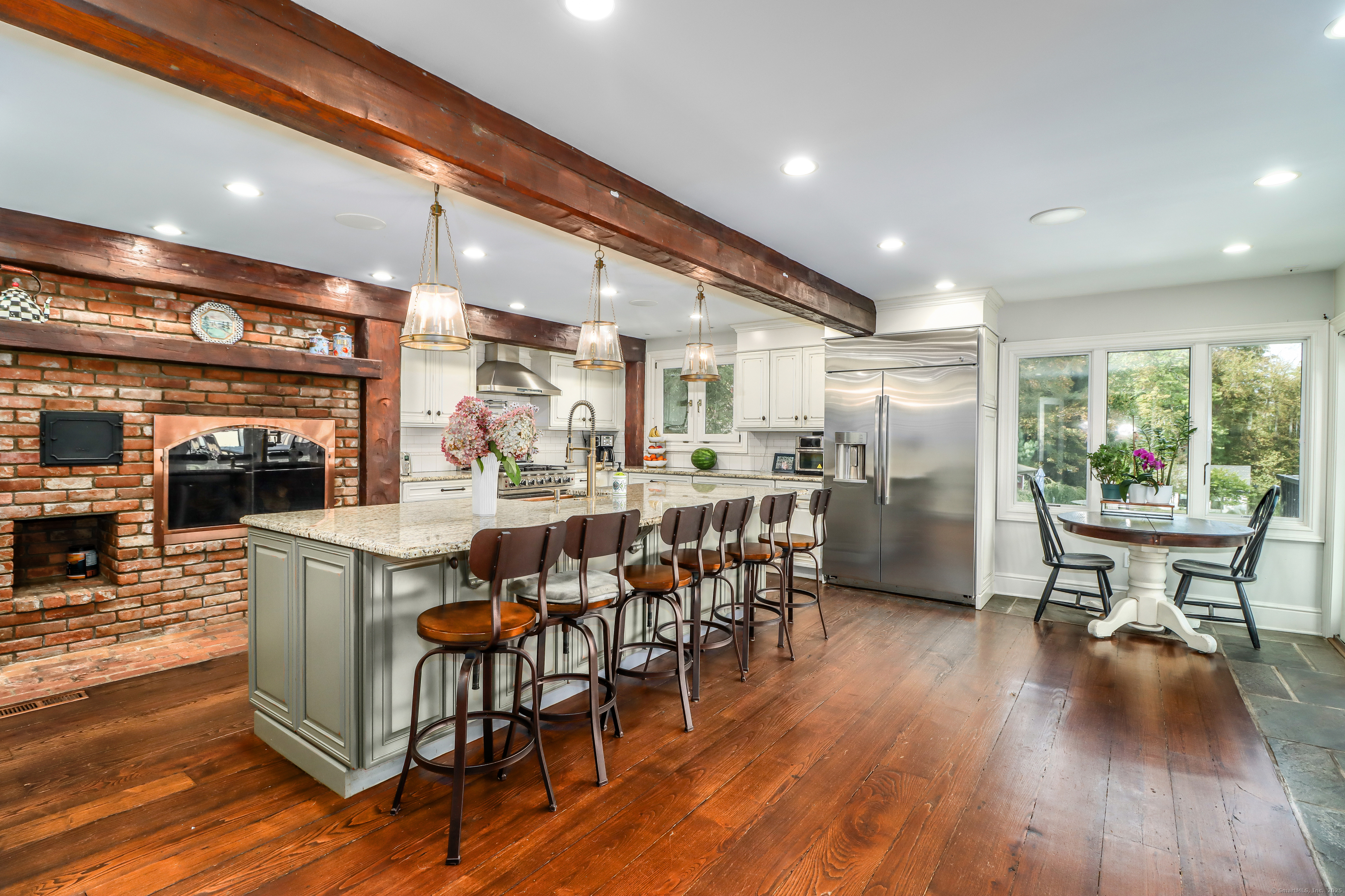 70 Obtuse Hill Road Brookfield, CT 06804 - Photo 11 of 37 a kitchen with stainless steel appliances kitchen island granite countertop a table chairs and a wooden floor