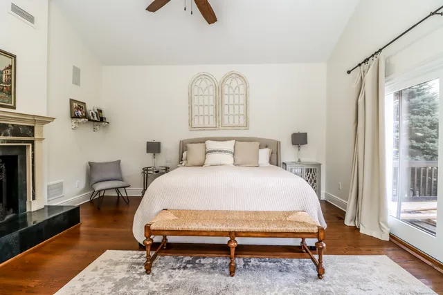 a bedroom with a bed a rug and wooden floor