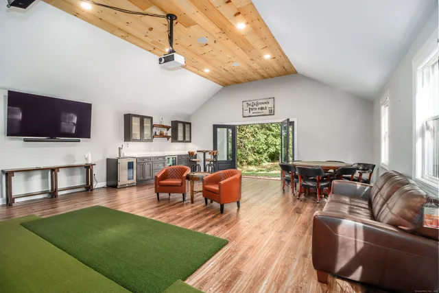 a living room with furniture a rug and a flat screen tv