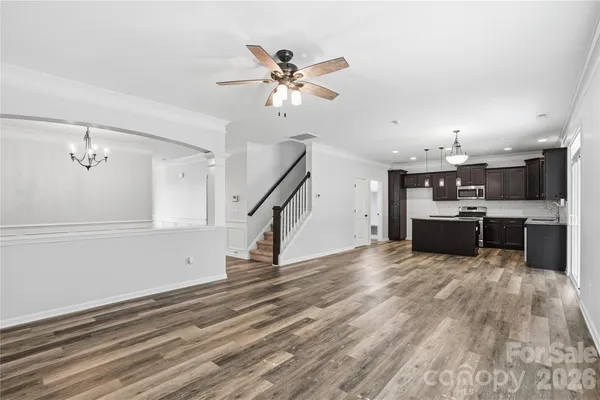 a large kitchen with stainless steel appliances kitchen island a large counter top and a wooden floors