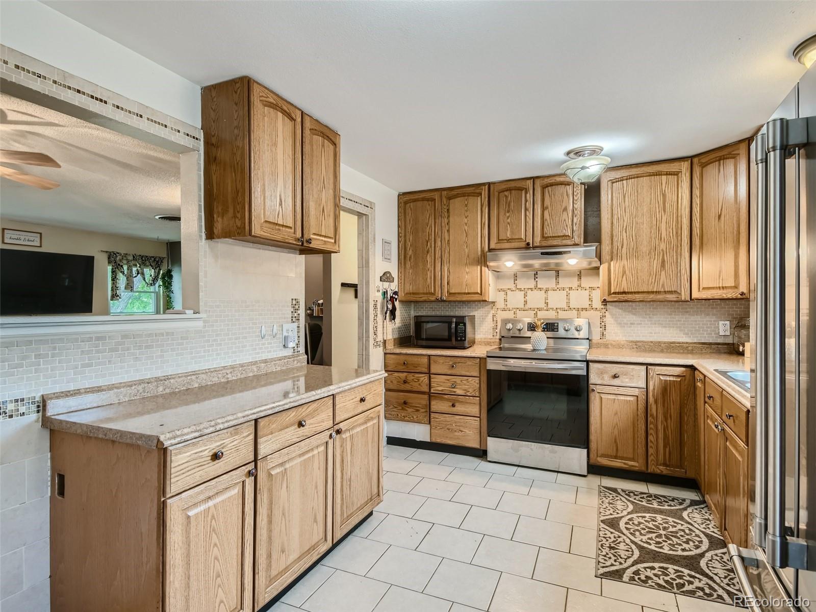 11111 Hudson Place Thornton, CO 80233 - Photo 11 of 28 a kitchen with stainless steel appliances granite countertop a stove a sink and a refrigerator