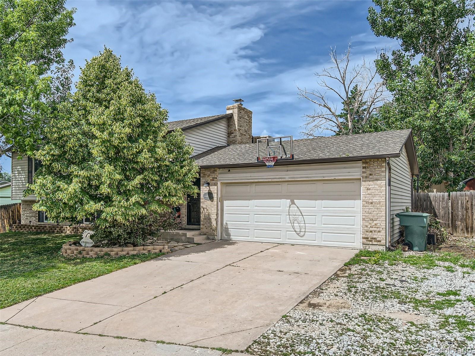 11111 Hudson Place Thornton, CO 80233 - Photo 2 of 28 a front view of a house with a yard and garage