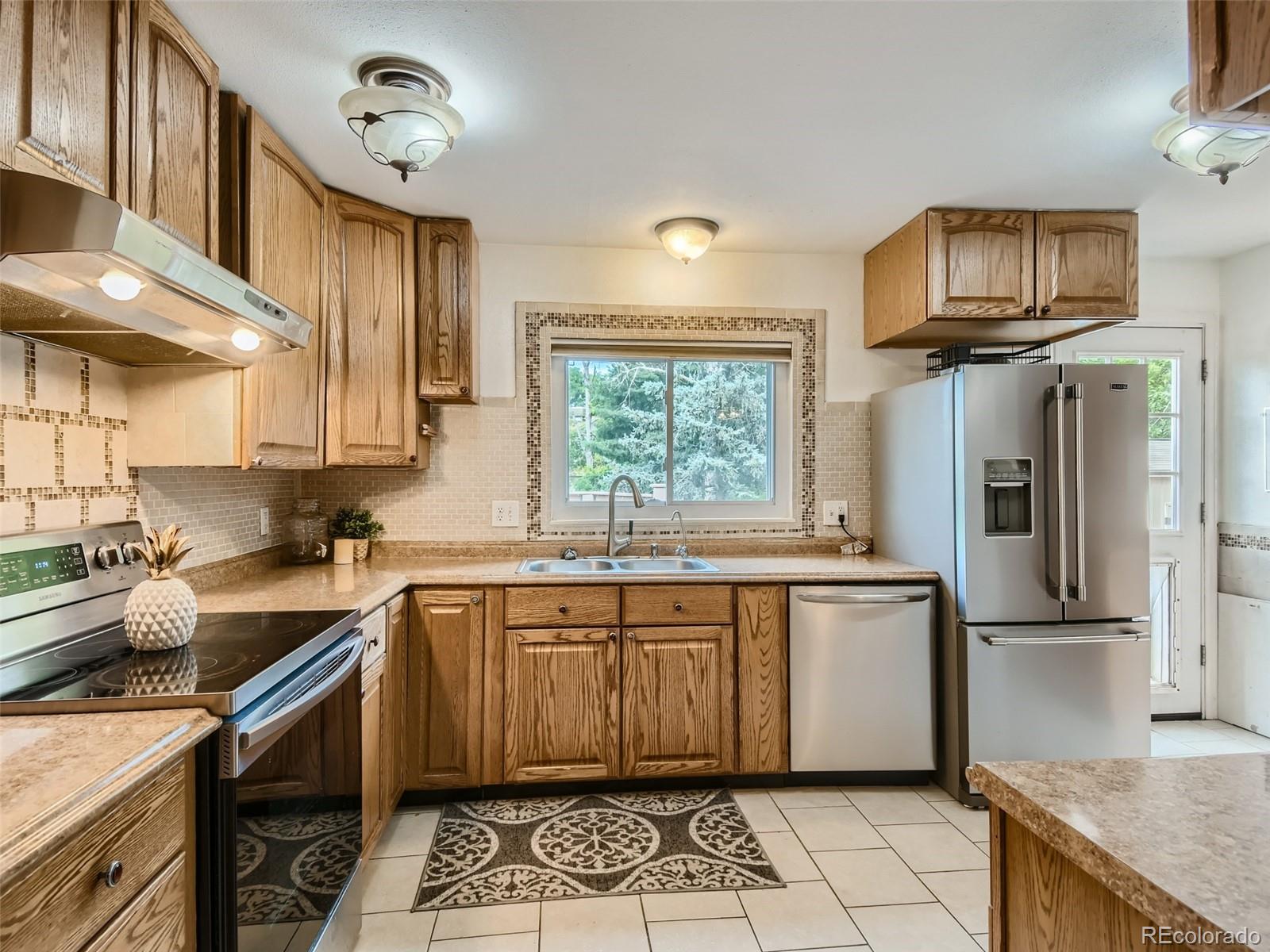 11111 Hudson Place Thornton, CO 80233 - Photo 9 of 28 a kitchen with stainless steel appliances granite countertop a sink stove and refrigerator
