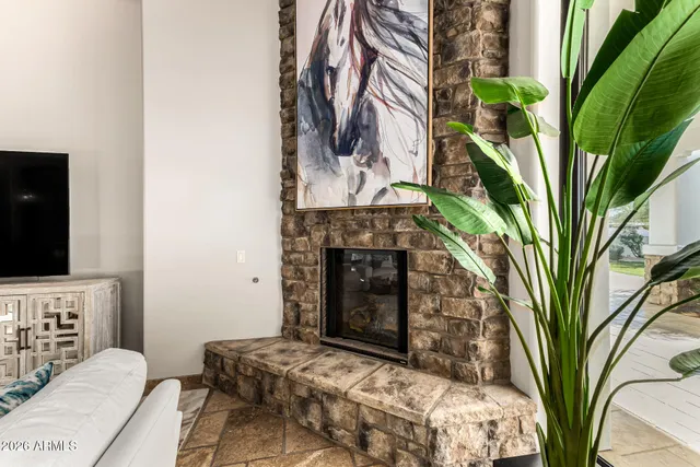 a bedroom with a bed a flat screen tv and a fireplace