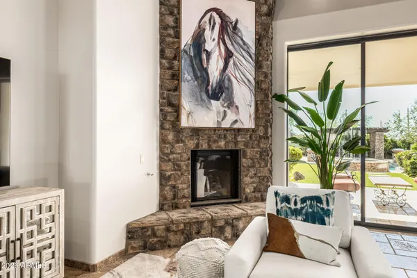 a living room with a fireplace and a potted plant