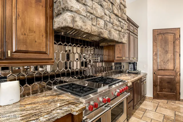 a kitchen with stainless steel appliances granite countertop a refrigerator and a stove top oven