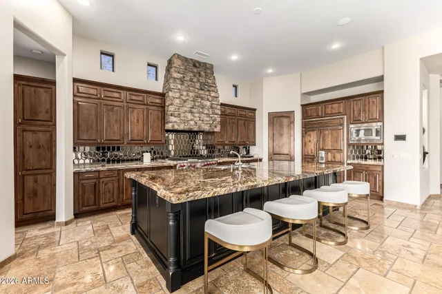 a kitchen with stainless steel appliances granite countertop a refrigerator and a stove top oven