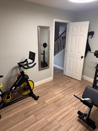 a view of a workspace with wooden floor and gym equipment