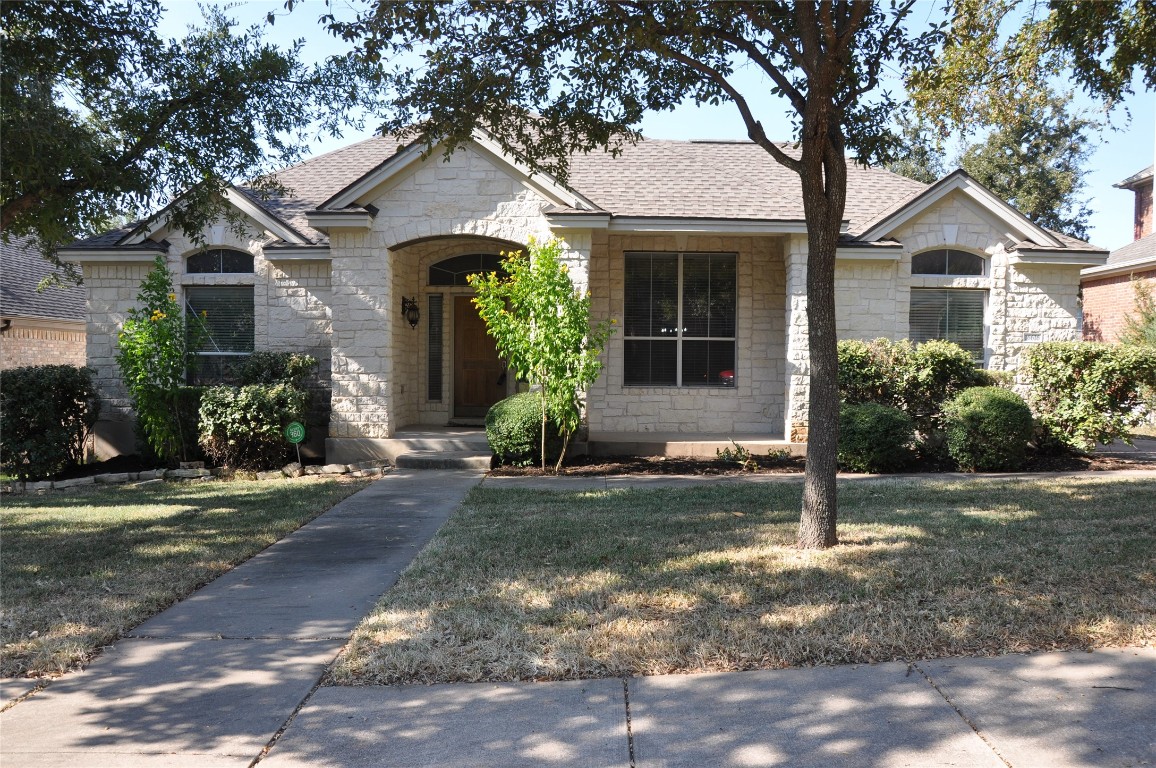 a front view of a house with a yard and potted plants
