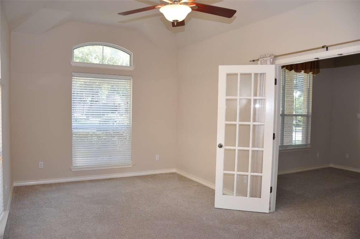 16616 Dalmahoy Drive Austin, TX 78717 - Photo 16 of 31 an empty room with a window a ceiling fan and wooden floor