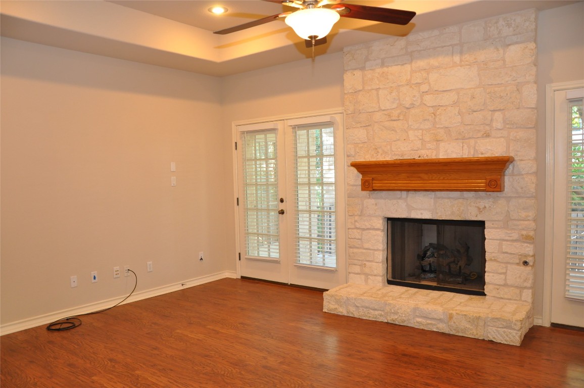16616 Dalmahoy Drive Austin, TX 78717 - Photo 8 of 31 a view of an empty room with wooden floor fireplace and a window
