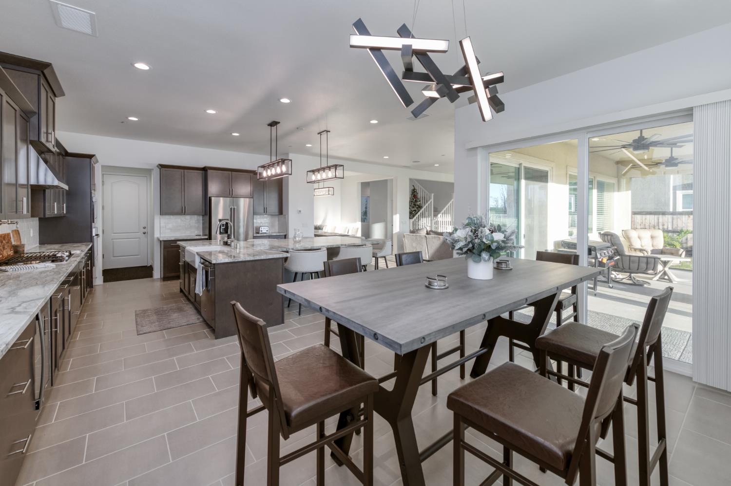 1042 Beaver Pond Loop Madera, CA 93636 - Photo 20 of 61 a dining room with stainless steel appliances kitchen island granite countertop a dining table chairs and a refrigerator