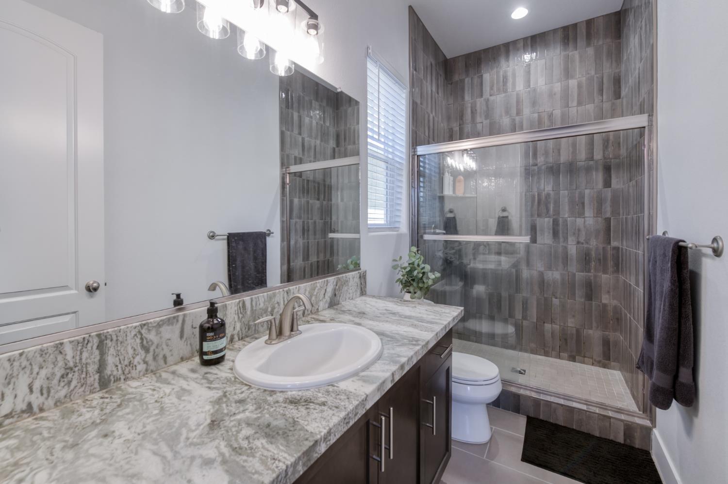 1042 Beaver Pond Loop Madera, CA 93636 - Photo 27 of 61 a bathroom with a sink toilet and shower