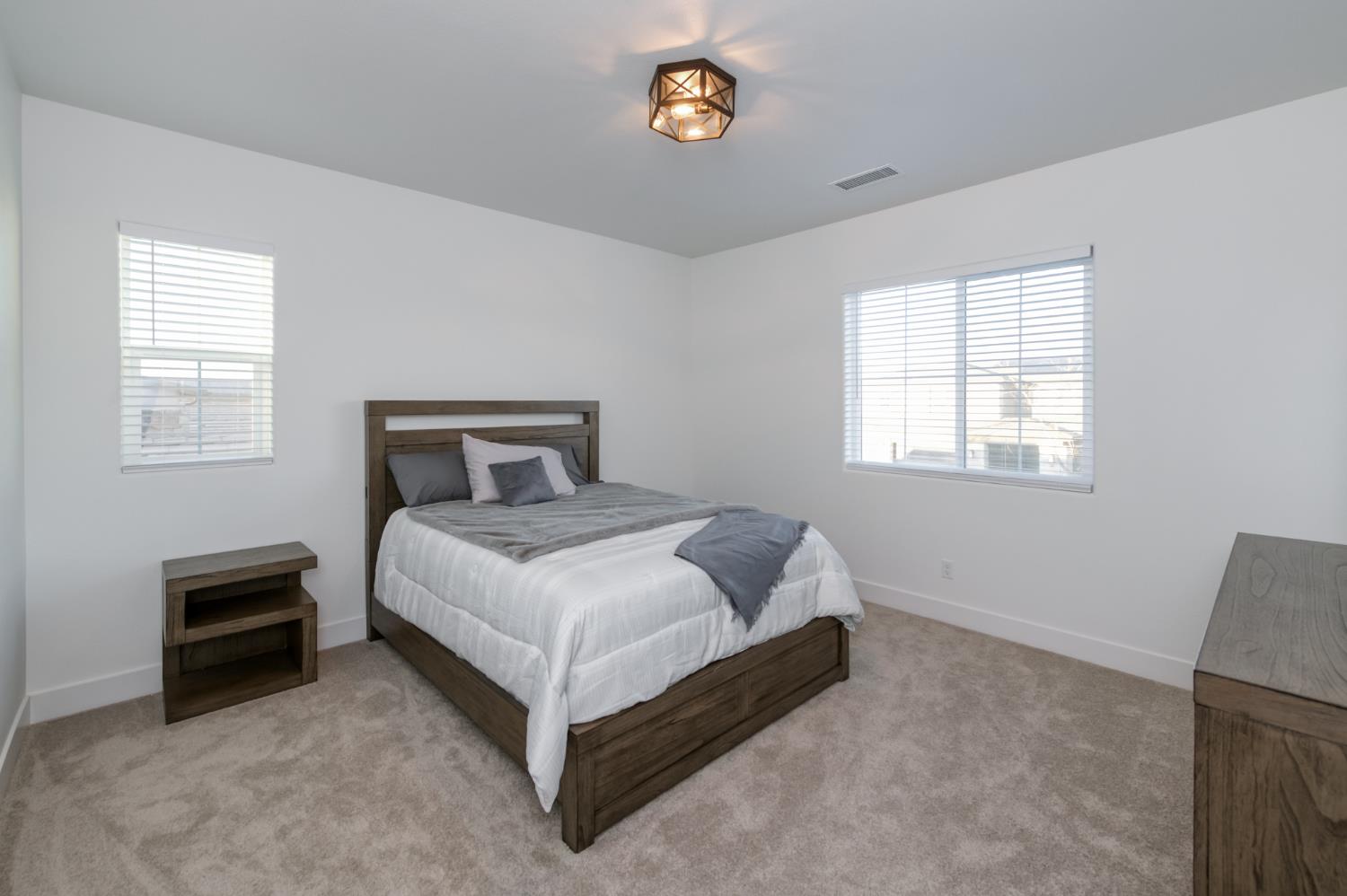 1042 Beaver Pond Loop Madera, CA 93636 - Photo 35 of 61 a bedroom with a bed lamp and a window