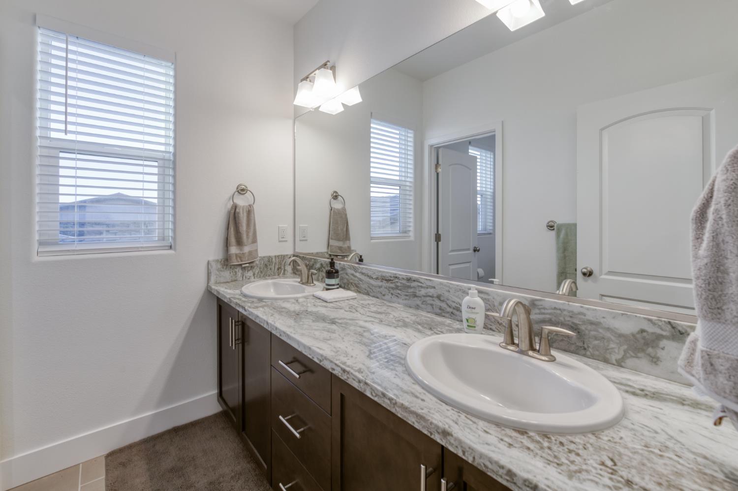 1042 Beaver Pond Loop Madera, CA 93636 - Photo 36 of 61 a bathroom with double sink and a mirror