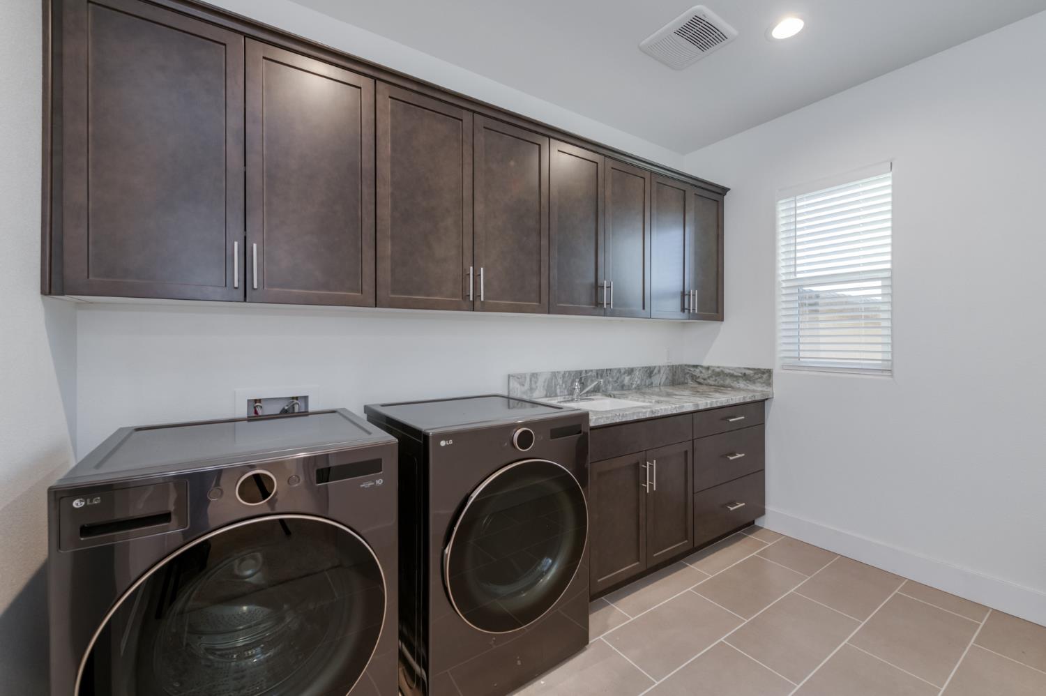 1042 Beaver Pond Loop Madera, CA 93636 - Photo 38 of 61 a utility room with sink dryer and washer
