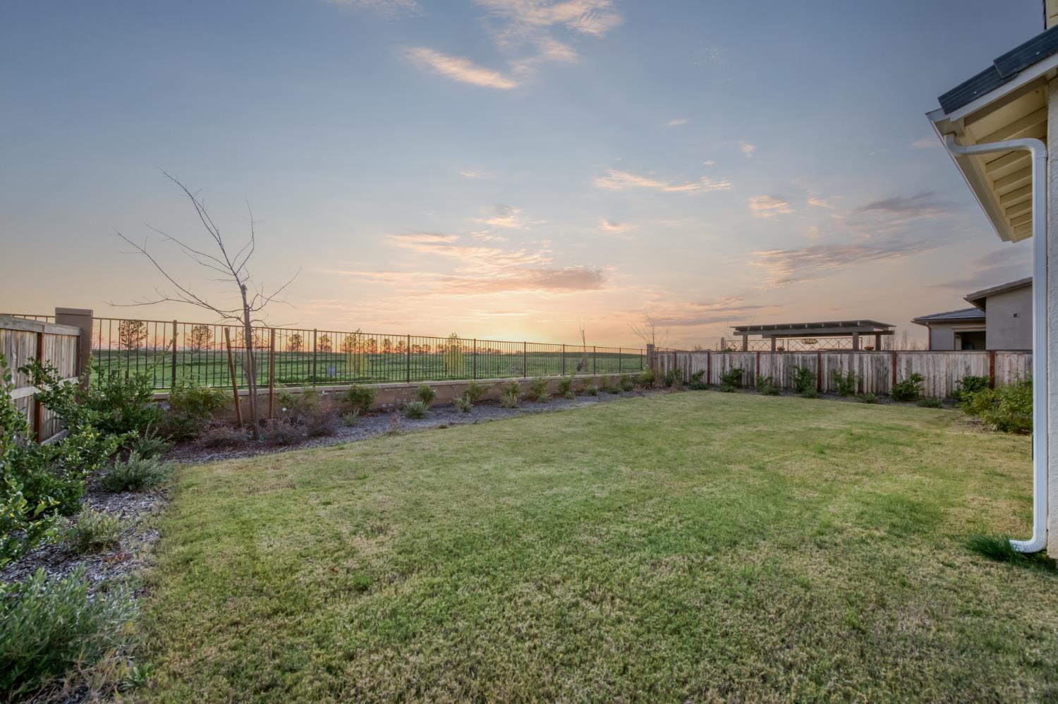 1042 Beaver Pond Loop Madera, CA 93636 - Photo 50 of 61 a view of a field of grass and a building