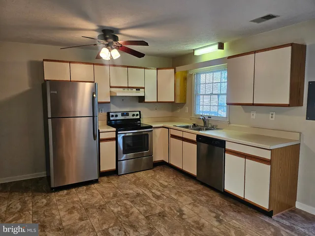 a kitchen with granite countertop a refrigerator and a sink