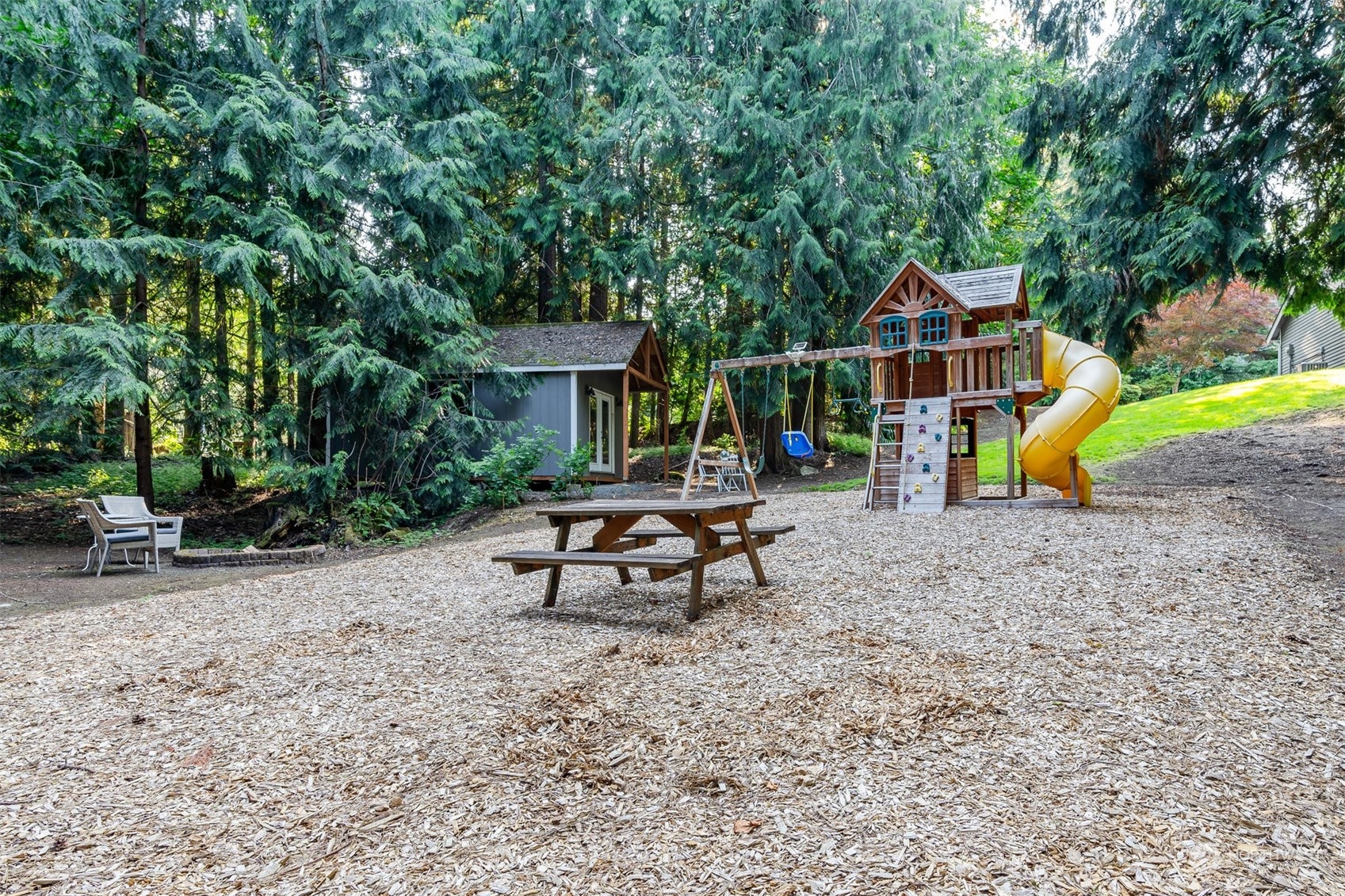 27403 Northeast 30th Way Redmond, WA 98053 - Photo 27 of 34 a view of a small house with a bench and sitting area