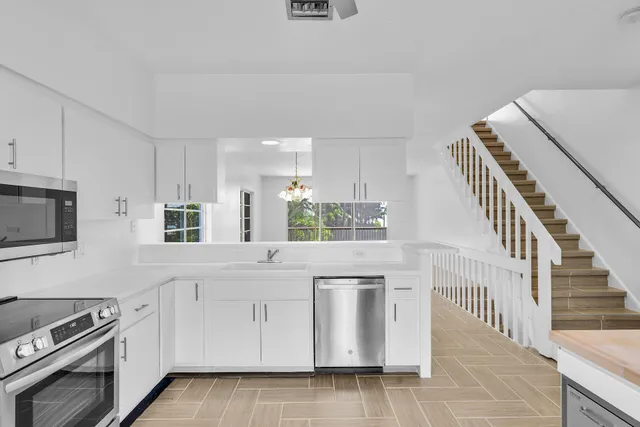 a kitchen with white cabinets and appliances